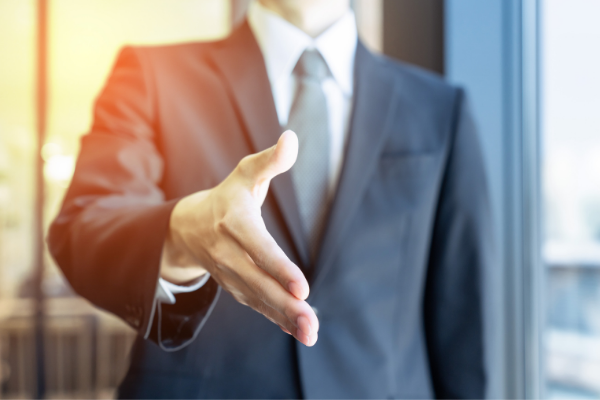 Partial view from neck down of business man hand out ready to shake
