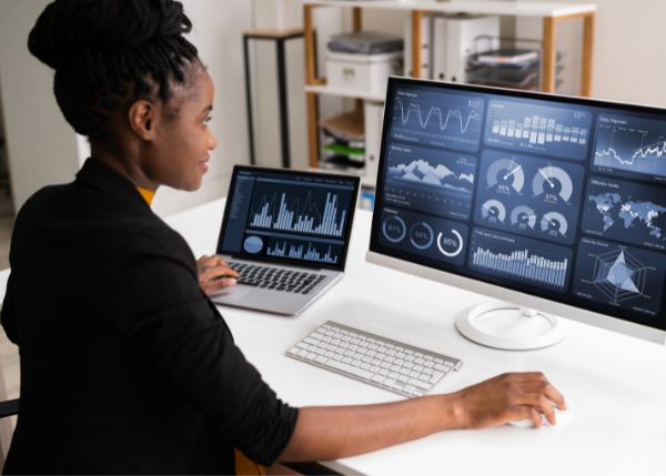 A woman looking at a data dashboard on a pc