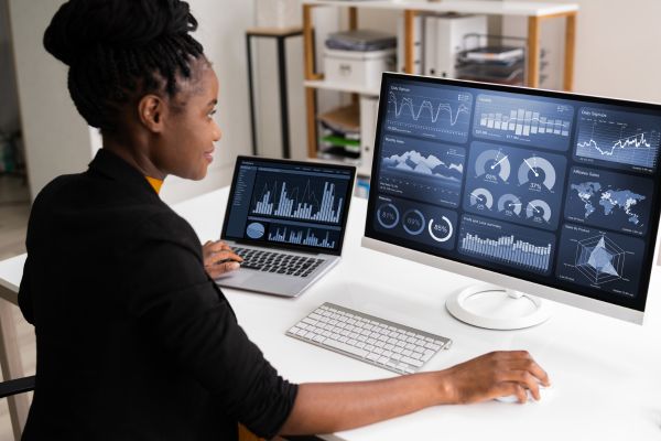 A woman looking at a data dashboard on a pc