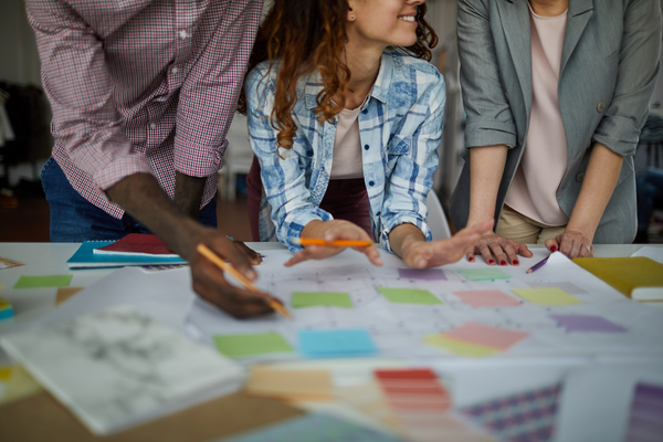 three people working together with sticky notes