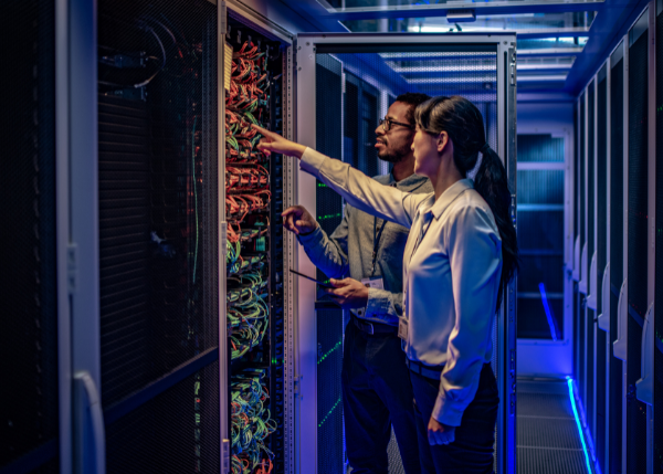 two people standing in hallway with data center