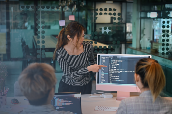 a woman pointing out an item on a screen to her colleagues