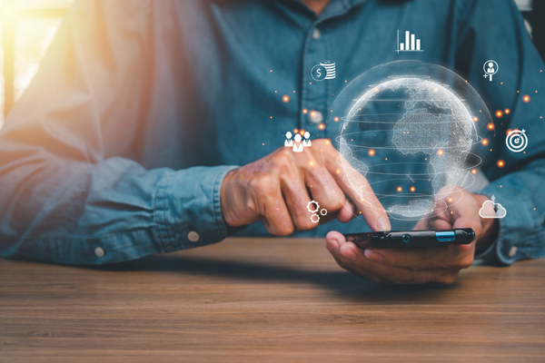 hands holding a phone with virtual finance-related icons