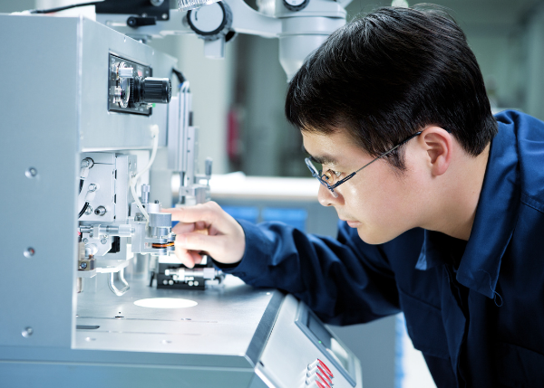 close up image of man looking at machinery in lab setting