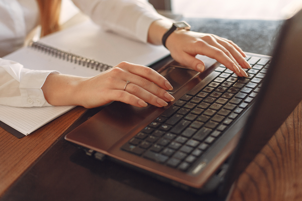 woman's hands typing on laptop
