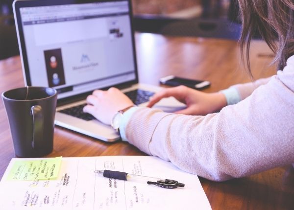 woman working with computer and sticky notes