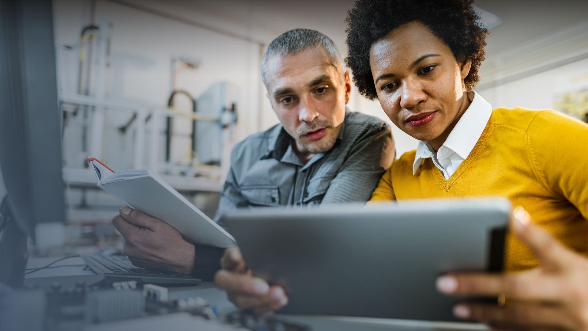 man and woman working together on tablets