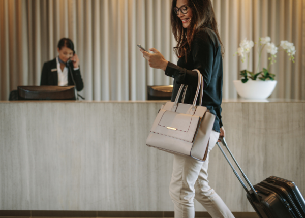 woman walking through hotel lobby with suitcase