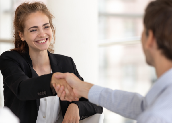 woman shaking man's hand and smiling