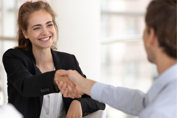 woman shaking man's hand and smiling