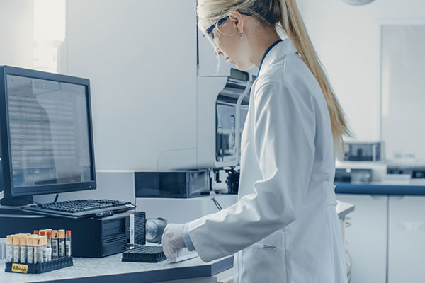 Woman in lab coat working on computer