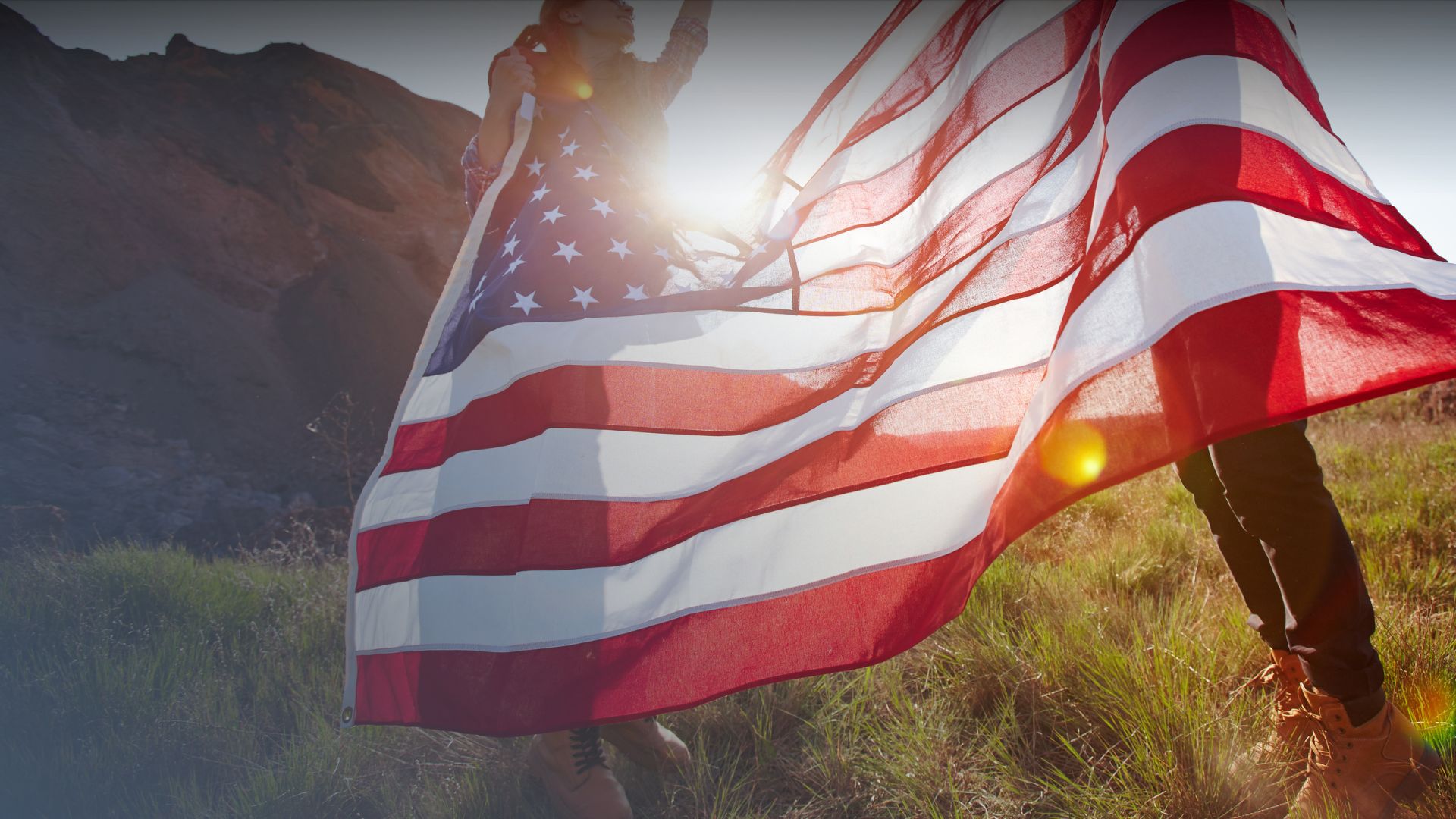 Two people holding the American flag