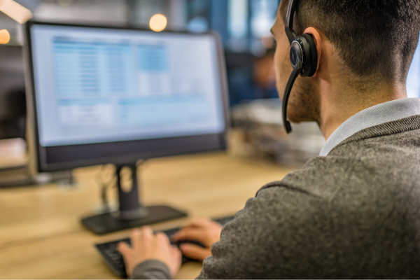 Man at computer with headset. Looks like a call center worker. 