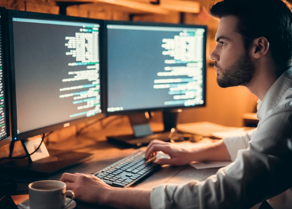 person coding on computer monitors