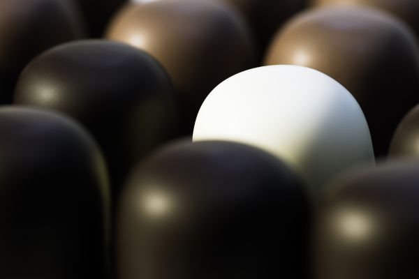 A single white stone amidst black stones