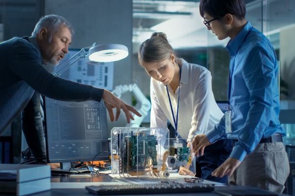 three engineers looking over a model with circuit boards