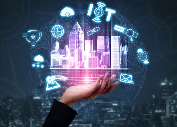 A hand holding a projection of a city with other icons floating