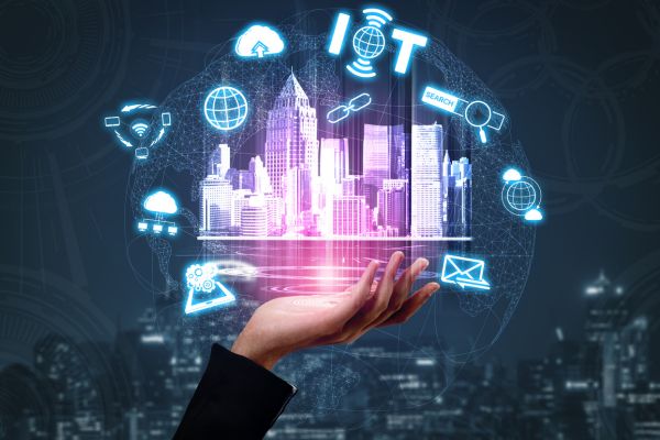 A hand holding a projection of a city with other icons floating