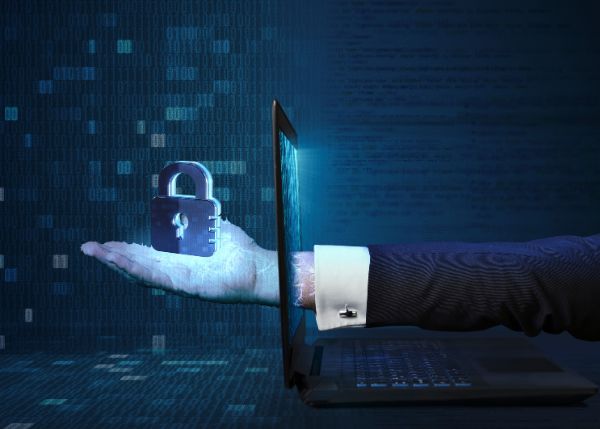 A hand reaching through a laptop holding a lock