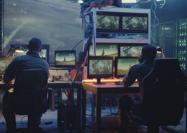 Two members of the military sitting at a computer bank