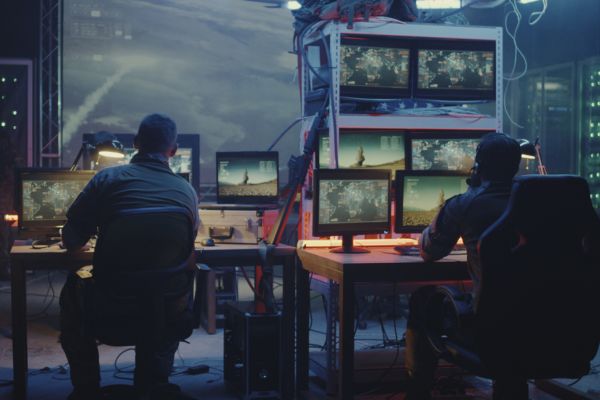Two members of the military sitting at a computer bank