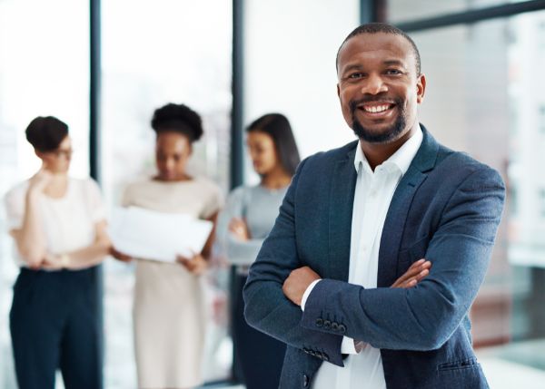 Business leader proudly standing with his team