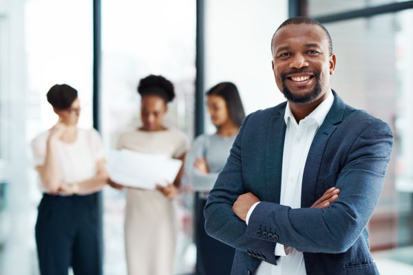 Business leader proudly standing in front of his teammates