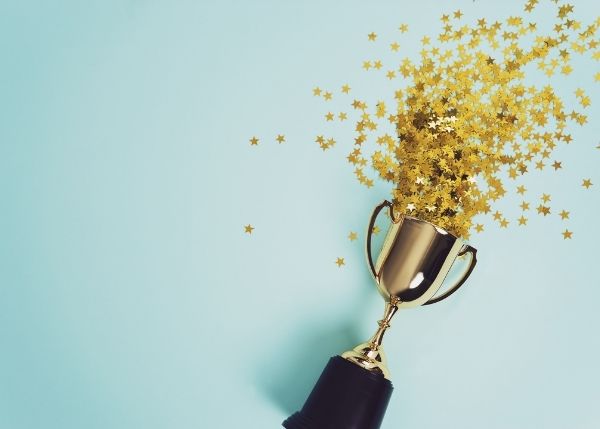 Golden star confetti emerging from the top of a trophy