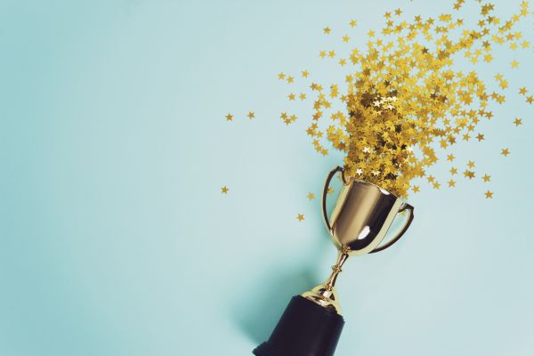 Golden star confetti emerging from the top of a trophy