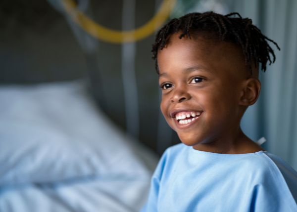 Small child smiling in a hospital gown