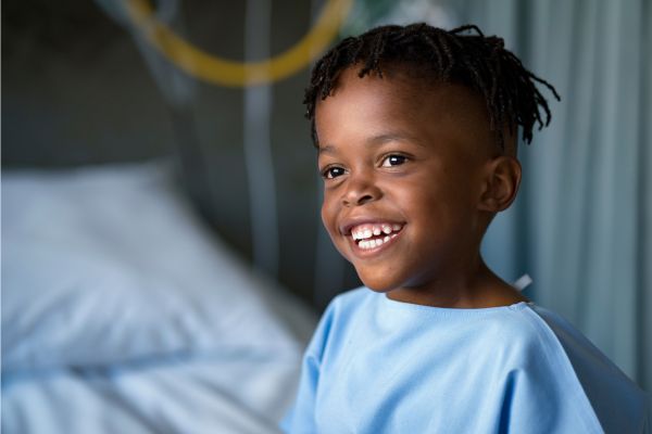 Small child smiling in a hospital gown