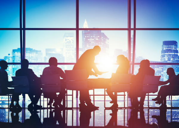 Business people gathered around a table and the sun shining through windows