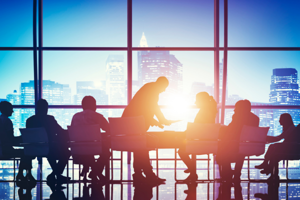 Business people gathered around a table and the sun shining through windows