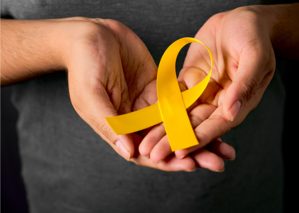 Open hands with a yellow ribbon