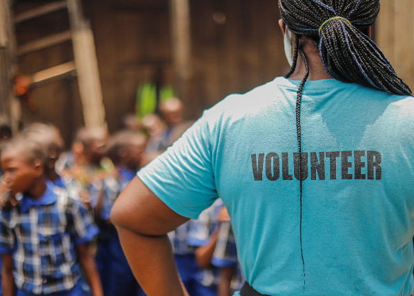 Volunteer standing before children in need