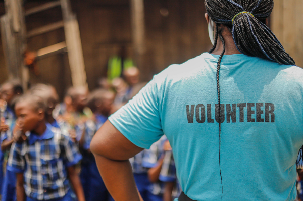 Volunteer standing before children in need
