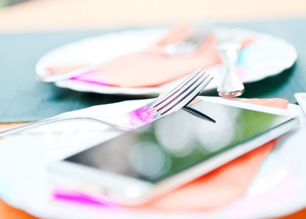 restaurant table setting with mobile phone