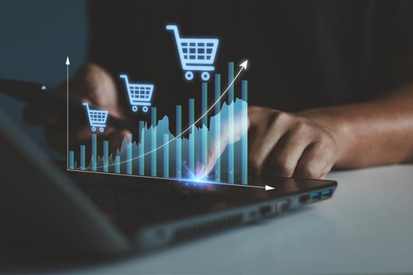 Person typing on laptop with graph of cart sales increasing