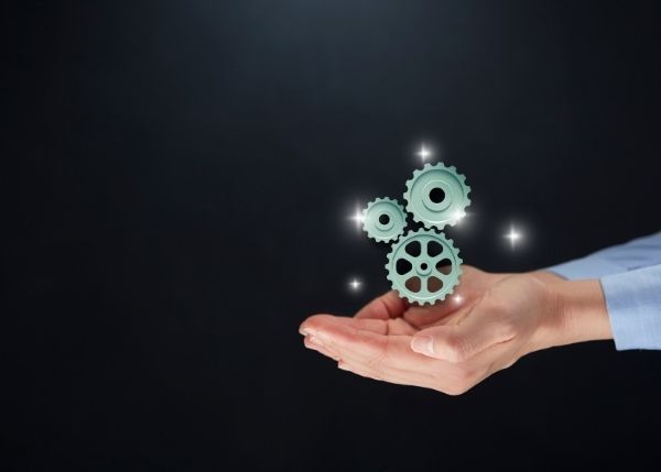 Cogs floating above someone's hands