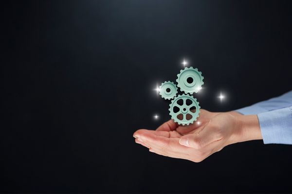 Cogs floating above someone's hands