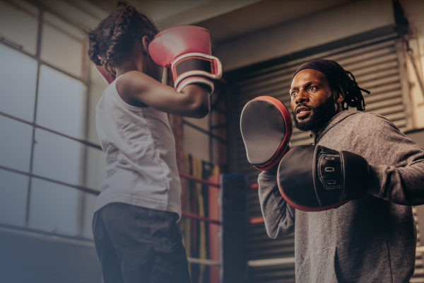 Child and man boxing and training