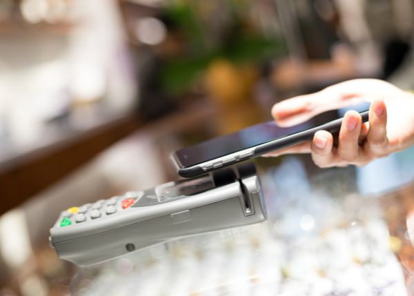close up image of hand holding phone up to card reader