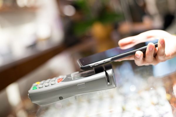 close up image of hand holding phone up to card reader