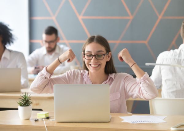 Happy employee looking at her laptop