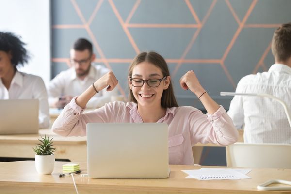 Happy employee looking at her laptop