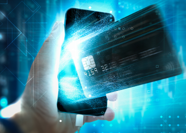 Hand holding a smartphone and a payment card