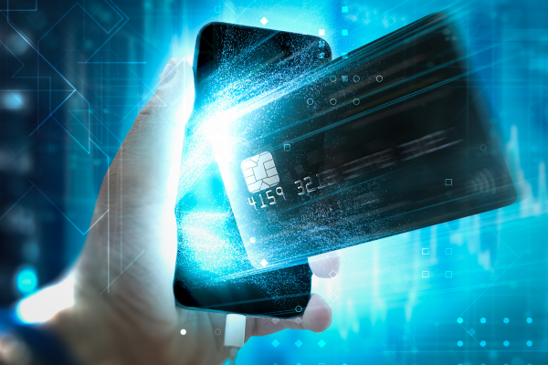 Hand holding a smartphone and a payment card
