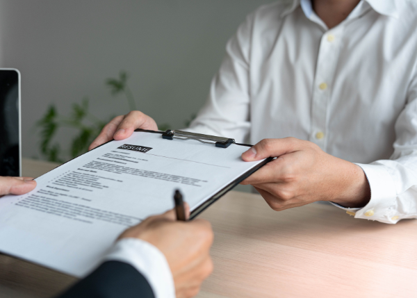 Hiring manager taking a resume from a candidate.