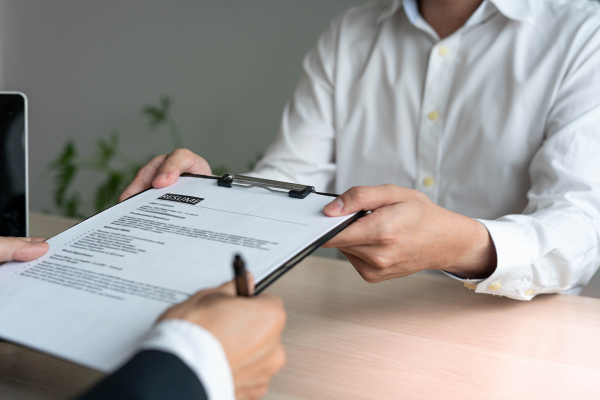 Hiring manager taking a resume from a candidate.