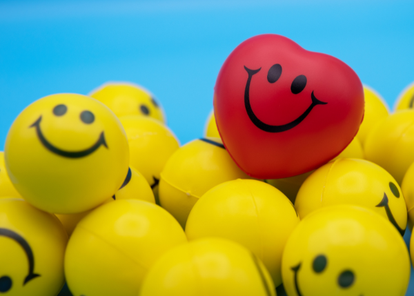 Yellow plastic smiley faces with a red heart smiling
